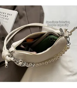 Detail of off-white shoulder bag interior showing spacious capacity for phone and cosmetics