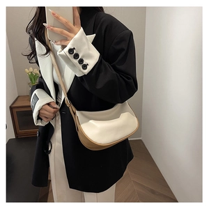 Detail view of a two-tone PU leather crescent bag with adjustable shoulder strap