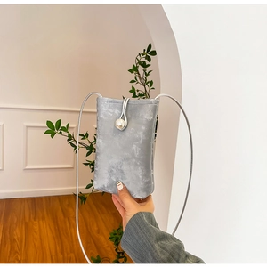 Detail shot of light grey textured mini crossbody phone bag with pearl buckle closure