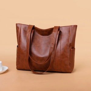 Minimalist large brown faux leather tote bag with side pockets and long shoulder straps