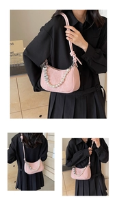 Detail of pink pleated half-moon bag featuring pearl heart chain and thin strap