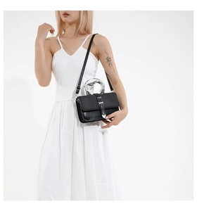 Détail du sac en cuir noir avec rabat tissé et poignée géométrique argentée
