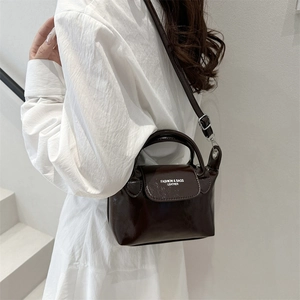 Fashionable dark brown leather crossbody bag with rounded handle and adjustable strap