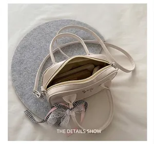 Detail view of white cat-ear bowling bag interior capacity with cute bow accessories