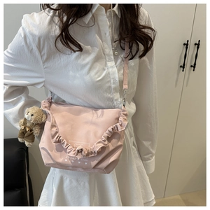 Light pink shoulder bag with ruffled edges and cute plush bear charm detail