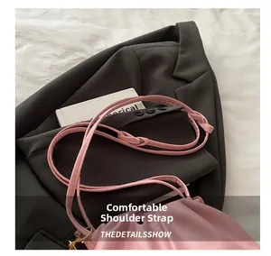 Detailed shot of pink leather shoulder strap with golden metal hook on textured background