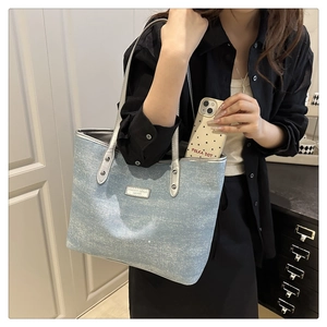 Light blue glitter tote bag with silver handles showing large capacity in daily use