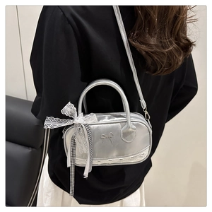 Silver metallic shell bag with bow charm, lace ribbon detail and leather shoulder strap