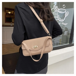 Detail of beige shoulder bag with golden oval twist lock and smooth faux leather texture