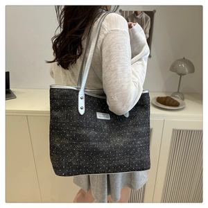 Polka dot tote bag detail with silver straps and fashion metal logo plaque on canvas