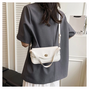 White minimalist square crossbody bag with gold lock buckle shown on model in modern setting
