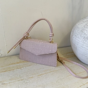 Minimalist light pink crossbody bag with polka dot embroidery and a top handle
