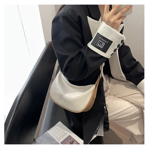 Detail showing white and brown leather contrast stitching on a stylish crescent bag