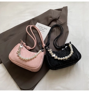 Detail of ruched leather texture with elegant pearl beads and silver heart charms