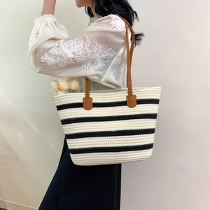 Woven striped cotton rope tote bag with brown leather handles for beach or commute