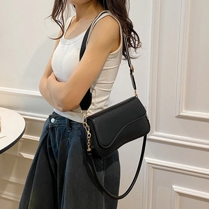 Sac bandoulière carré noir minimaliste avec rabat asymétrique et chaîne dorée