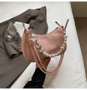 Detailed macro view of pink underarm bag with marble texture and pearl heart chain strap
