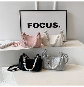 Detailed close-up of textured mini bags in four colors with pearl and heart chain details