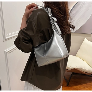 Detail view of metallic silver hobo bag with bow decoration and stylish pleated texture