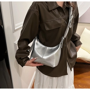 Détail d'un sac hobo argenté avec un nœud décoratif sur la bandoulière élégante