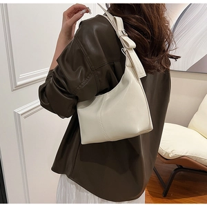 Close-up of cream hobo bag featuring a stylish bow knot and smooth faux leather finish