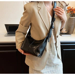 Chic black matte hobo bag styled with a beige blazer in a professional office setting