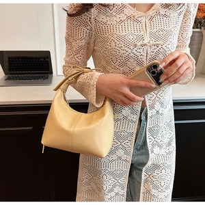Detail of cream crescent hobo bag showing smooth leather texture and vertical stitching
