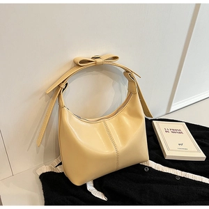 Détail du sac hobo crème montrant les coutures fines et le nœud décoratif sur la poignée