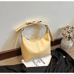Détail du sac à bandoulière jaune crème avec nœud et finitions de couture premium