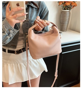 Détail du sac à main plissé rose avec ferrures dorées et bandoulière amovible