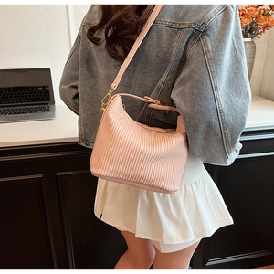 Détail du sac hobo plissé rose clair avec ferrures dorées et bandoulière élégante