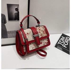 Close-up of Chinese style handbag with red plum blossom embroidery and metallic buckle
