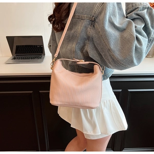 Détail du sac bandoulière plissé rose avec texture verticale et boucles en métal doré