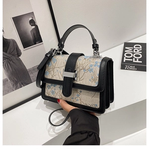 Detail of floral embroidery and silver H-shaped metal buckle on the fabric square handbag