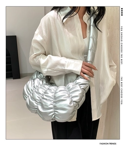 Close-up of metallic silver pleated cloud bag showing large capacity and puffy texture