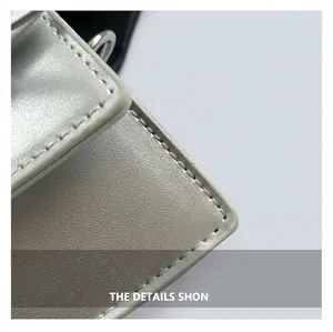Macro detail of silver pebbled leather texture and neat stitching on a mini square bag