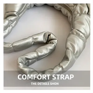 Detail of silver metallic cloud bag featuring quilted texture and thick shoulder strap