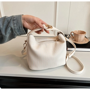 Détails du velours côtelé blanc et du fermoir doré sur le petit sac bandoulière