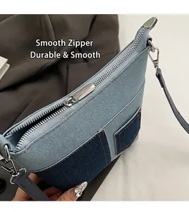 Details des glatten silbernen Reißverschlusses und Patchwork-Denim der Schultertasche