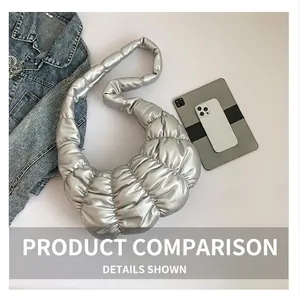 Top view of a metallic silver quilted cloud bag next to a denim jacket and tablet