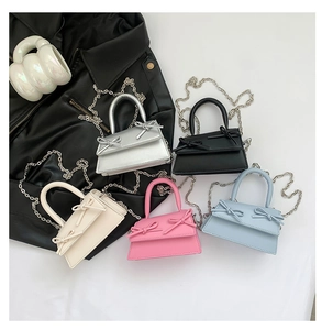 Detailed display of five colorful mini bags with dual bow accents and chain straps