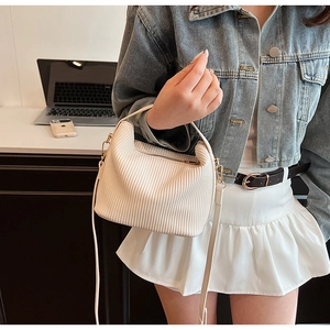Détail du sac à main plissé blanc avec bandoulière amovible et finitions dorées