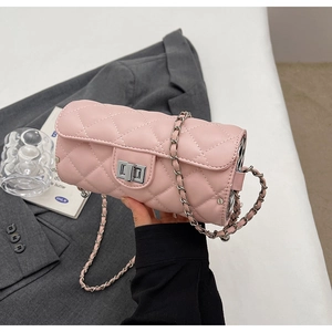 Gros plan du sac cylindrique rose matelassé avec fermoir rotatif argenté et chaîne
