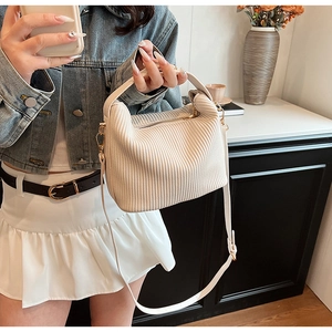 Détail d'un sac à main blanc crème plissé avec poignée et fermeture éclair en métal