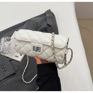 Gros plan du sac cylindre blanc matelassé avec fermoir argenté et bandoulière chaîne