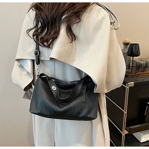 Detail of vintage black pleated leather texture and silver buckle on a handbag
