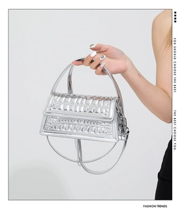 Detailed view of silver glossy handbag featuring textured embossed finish and metallic luster