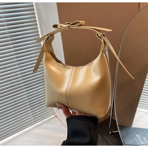 Détail d'un sac seau en cuir PU jaune clair avec un nœud décoratif sur la poignée