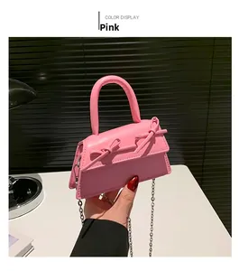 Close-up of pink mini bag featuring double bow accents and silver chain strap details