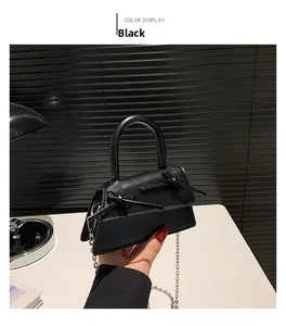 Detail of black mini trapezoid handbag with silver chain and double bow design